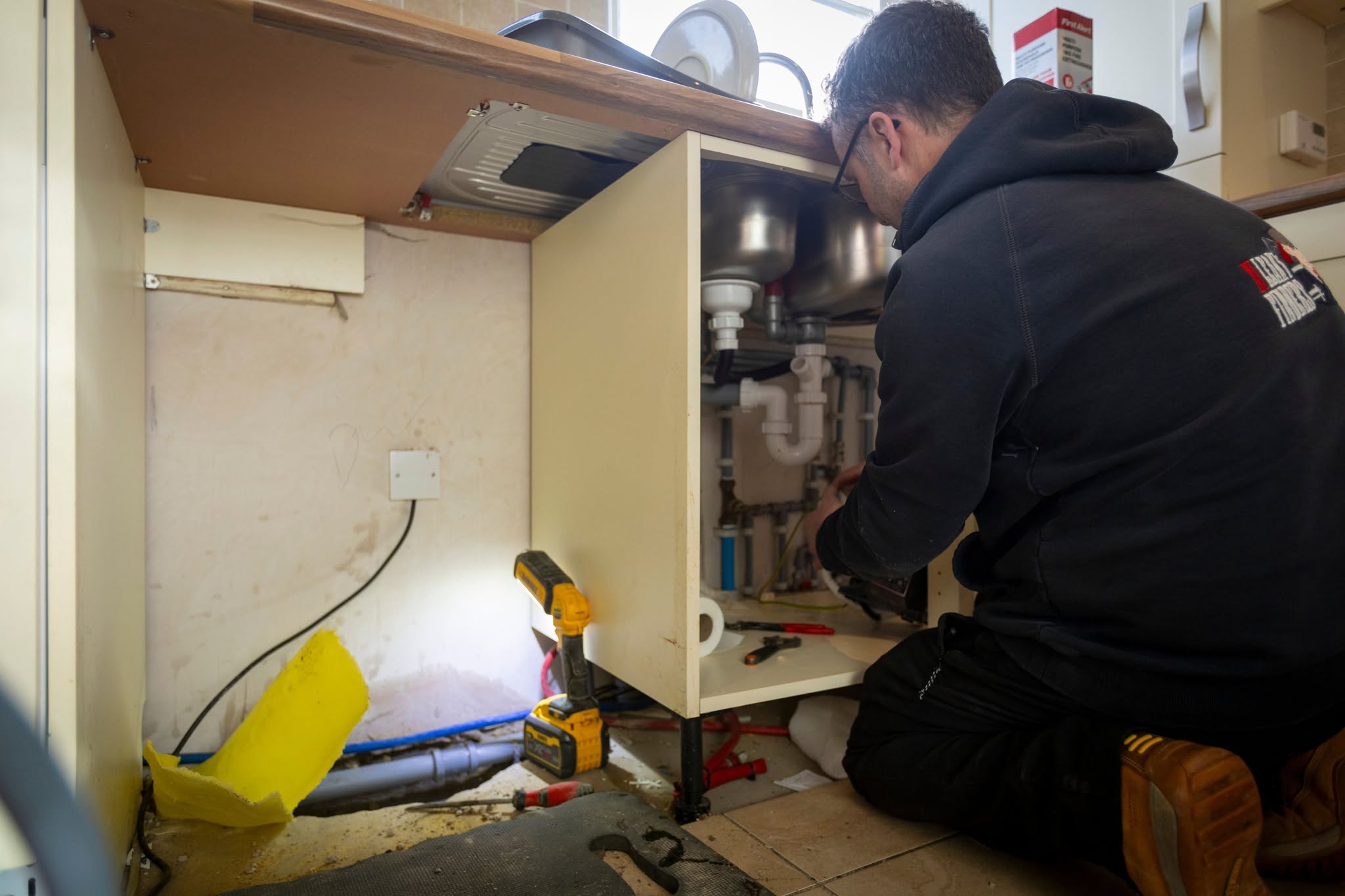 Man fixing leak on kitchen sink